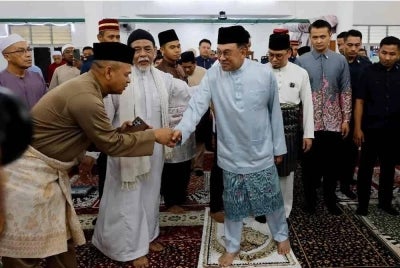 Anwar beramah mesra dengan jemaah selepas menunaikan solat Jumaat di Surau Bomba Cyberjaya. 