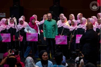 Anwar menonton persembahan 'Winds of Glory' oleh pasukan orkestra SPWinds bersama Amir Masdi di PICC. Foto: Pejabat Perdana Menteri