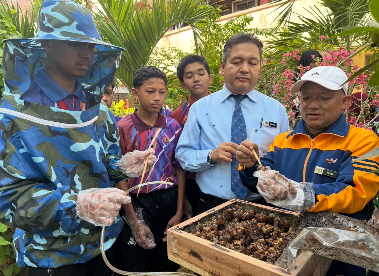 Mohd Rosli (kanan) menunjukkan roti lebah yang terhasil.
