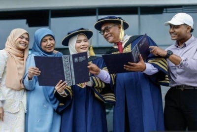 Jafni (dua dari kanan), Nurul Huda (tiga dari kiri) diraikan ahli keluarga selepas kedua-duanya menerima PhD pada Istiadat Konvokesyen UiTM ke-104.