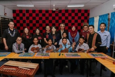 Josephine (belakang, tengah) dan Stefanus (depan, kanan) serta tetamu yang hadir bersama pelajar berkeperluan khas di Bilik Muzik Inklusif yang telah dinaik taraf.