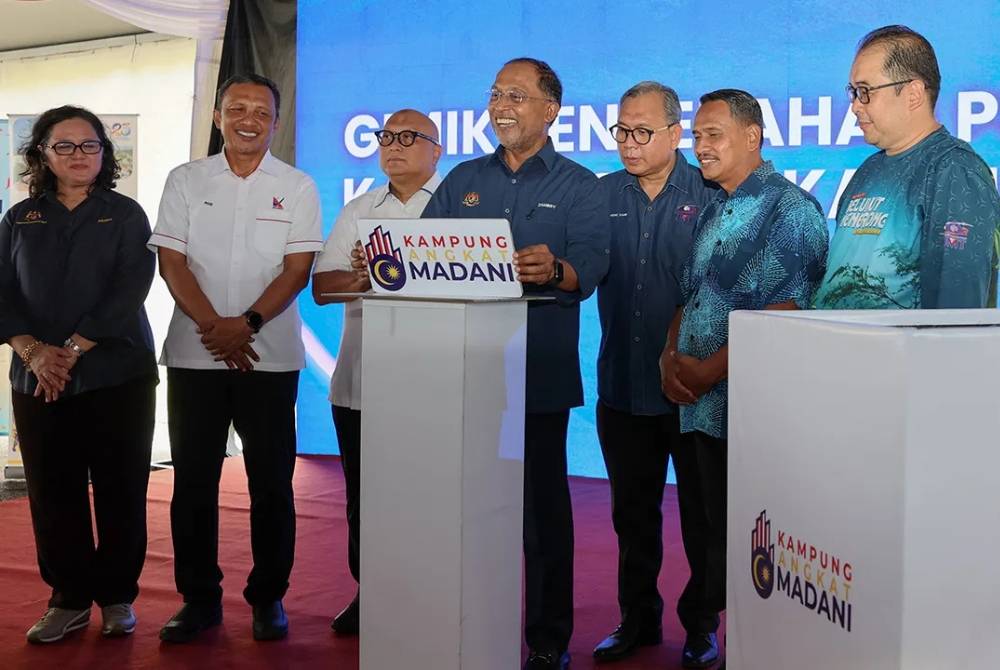 Zambry (tengah) melakukan gimik Penyerahan Projek Kampung Angkat MADANI UMT Kampung Menerong di Sekolah Menengah Kebangsaan Menerong, Ajil. 