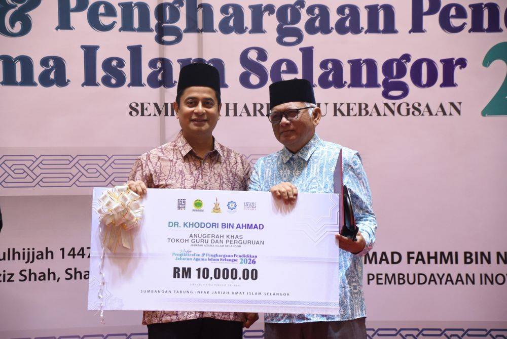 Dr Khodori (kanan) menerima Anugerah Tokoh Khas Guru dan Perguruan daripada Mohammad Fahmi (kiri) dalam Majlis Pengiktirafan dan Penghargaan Pendidikan JAIS sempena Hari Guru Kebangsaan 2026. 