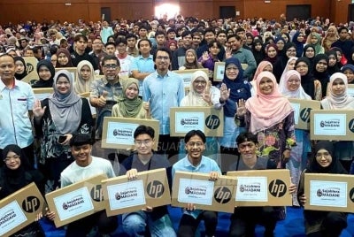 Muhammad Kamil (tengah) bersama penerima pada Program Sumbangan Komputer Riba dan Bantuan Awal Ke Institusi Pengajian Tinggi kepada anak-anak eKasih Cemerlang SPM 2025 Negeri Kelantan, Jajahan Kota Bharu. 