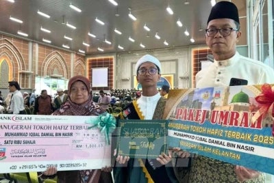 Muhammad Iqbal Danial (tengah) bersama ibu bapanya. 