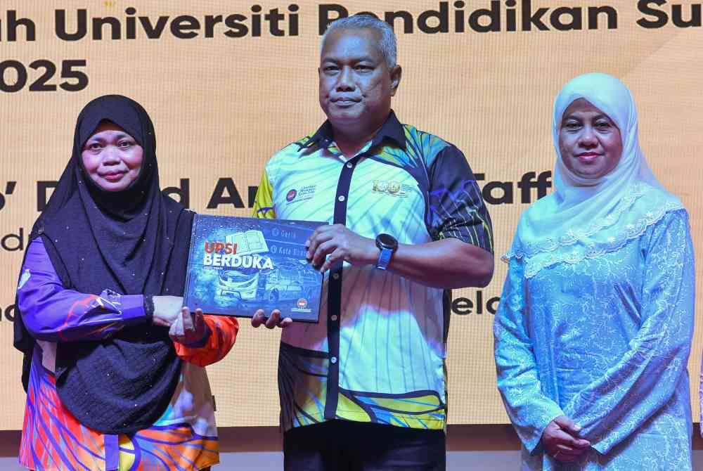 Md Amin (tengah) menerima penyerahan buku 'UPSI Berduka' daripada Pengarah Pejabat Karang Mengarang UPSI, Profesor Madya Dr Nordiana Hamzah (kiri) pada Majlis Tautan Kasih dan Ukhwah UPSI Bersama Waris Insiden Gerik 2025 di Tok Bali, Kelantan.
