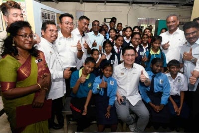 Kah Woh bersama murid-murid SJKT Rajaji semasa hadir pada majlis penyerahan surat kelulusan pembinaan bangunan baharu sekolah berkenaan. Hadir sama Guru Besar SJKT Rajaji, B.Lueis Mary (kiri).