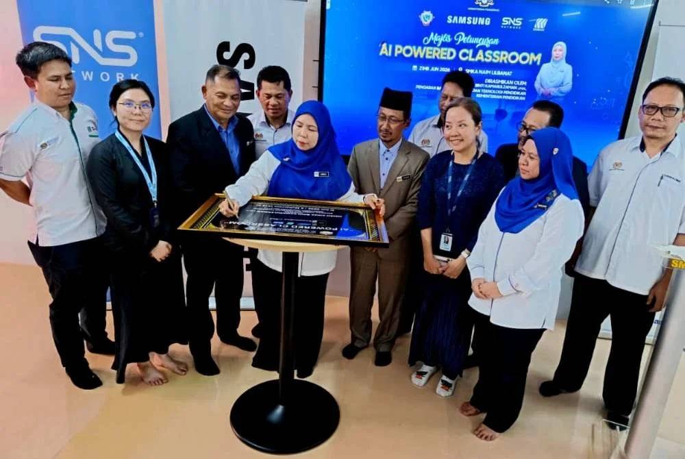 Ab Raisham (empat dari kanan) menyaksikan Aniza menandatangani plak sebagai gimik perasmian pada Majlis Perasmian AI-Powered Classroom SMKA Naim Lilbanat di Kota Bharu.