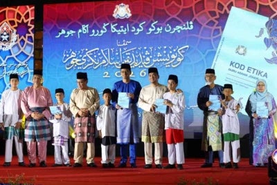 Onn Hafiz dan Mohd Fared (enam dari kiri) menerima buku kod etika guru agama Johor yang disampaikan oleh pelajar sekolah agama sebagai gimik pelancaran pada Sambutan Hari Guru Agama Kerajaan Johor Peringkat Negeri kali ke-28 dan Perasmian Penutup Program Konvensyen Pendidikan Islam Negeri Johor 2026 di Stadium Tertutup Arena Larkin.