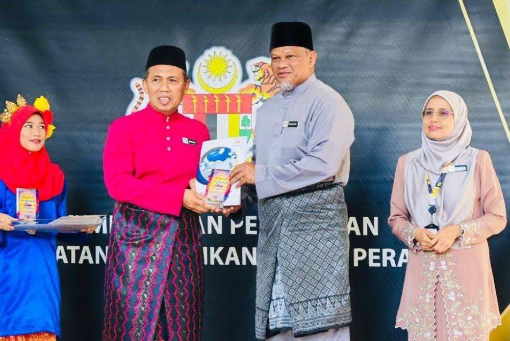 Pengarah Jabatan Pendidikan Negeri Perak, Zulkafli Mohamed Mokhtar (dua dari kiri), menyampaikan Pingat Gangsa Anugerah Kecemerlangan Asrama Harian Negeri Perak 2024 kepada Ustaz Ahmad Bakhtier (dua dari kanan).