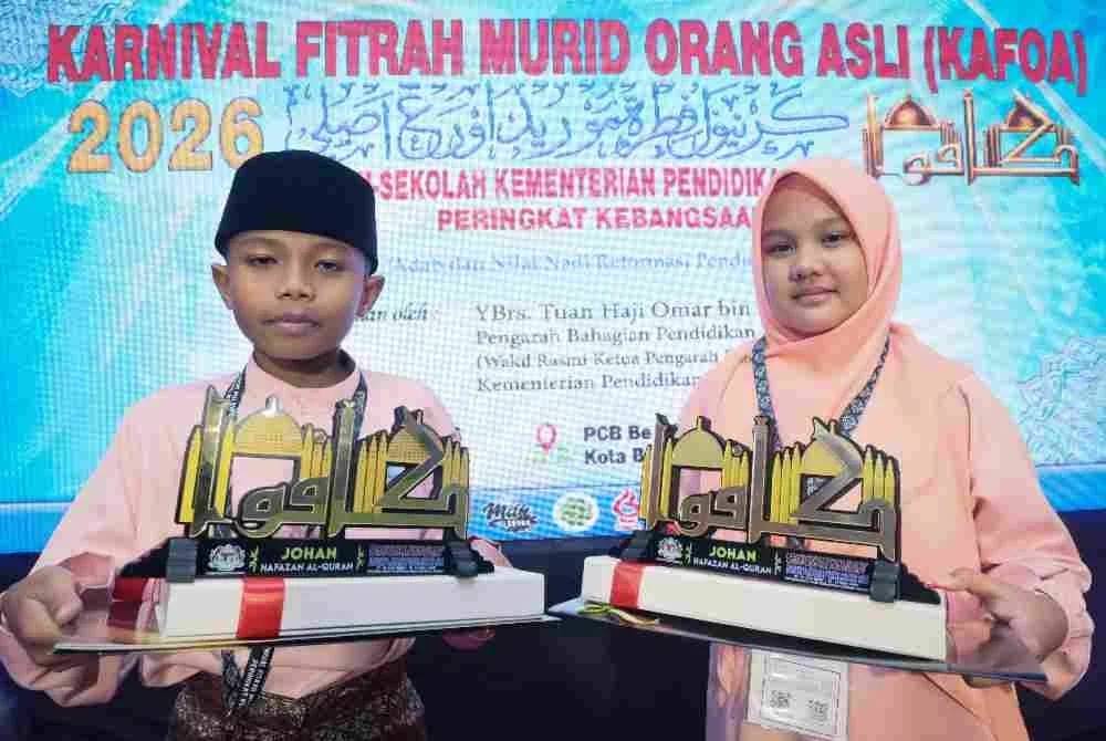 Johan hafazan al-Quran kategori lelaki dari Sekolah Kebangsaan (SK) Sungai Pusu, Muhamad Nazirul Hakim (kiri) dan johan hafazan al-Quran kategori perempuan (SK Gombak Utara), Nur Dalia Eryna bersama piala masing-masing pada Majlis Perasmian Penutup Karnival Fitrah Murid Orang Asli (KAFOA) Sekolah-Sekolah Kementerian Pendidikan Peringkat Kebangsaan Tahun 2026 di Pantai Cahaya Bulan, Kota Bharu, Kelantan. 