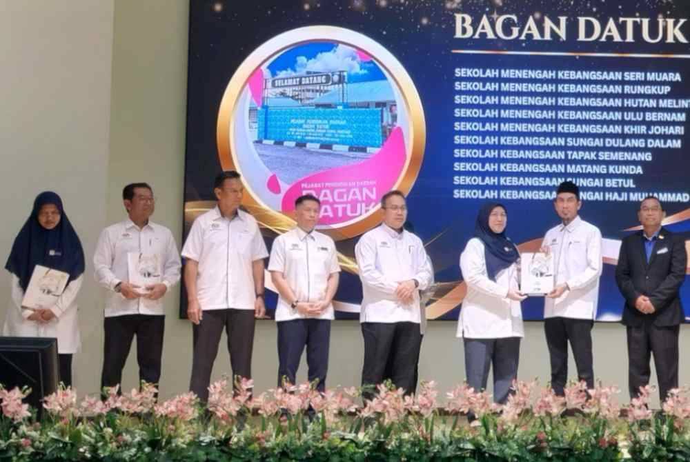 Salmah (tiga dari kanan) menyerahkan Surat Prakarsa Peningkatan Mutu Sekolah kepada Pengetua Sekolah Menengah Kebangsaan Hutan Melintang, Uzairi Ibrahim sempena Majlis Penyerahan Surat Prakarsa Peningkatan Mutu Sekolah Bawah Reformasi Sekolah sempena Pelaksanaan Rancangan Pendidikan Malaysia 2026-2035 di Dewan Serbaguna JPN Perak di sini pada Isnin.