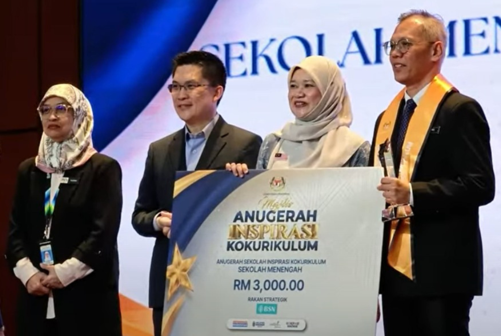 Teik Ming (kanan) menerima Anugerah Sekolah Inspirasi Kokurikulum daripada Menteri Pendidikan, Fadhlina Sidek.
