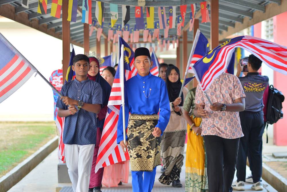 Perarakan masuk tetamu kehormat diringi pelajar berbilang kaum. JURUGAMBAR: ASRIL ASWANDI ABD SHUKOR