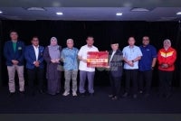 Ahmad Fadzli (lima dari kiri) menyerahkan tajaan kepada Emran di Kompleks Karangkraf pada Isnin. FOTO: MOHD HALIM ABDUL WAHID