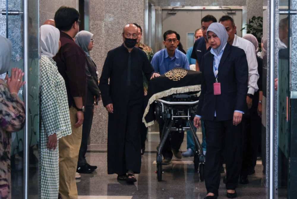 Datuk Seri Mukhriz Mahathir mengiringi jenazah ibunya, Tun Dr Hasmah di Institut Jantung Negara (IJN) hari ini. (Foto: Bernama)