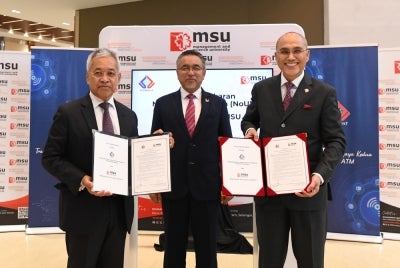 Adly (tengah) menyaksikan majlis pertukaran dokumen NoU di antara Mohd Shukri dan Amir di kampus induk MSU, Shah Alam. 