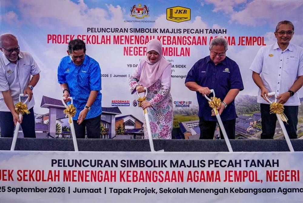 Fadhlina (tengah) melakukan gimik pecah tanah projek SMKA Jempol baru-baru ini. 