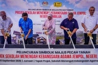 Fadhlina (tengah) melakukan gimik pecah tanah projek SMKA Jempol baru-baru ini. 