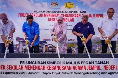 Fadhlina (tengah) melakukan gimik pecah tanah projek SMKA Jempol baru-baru ini. 