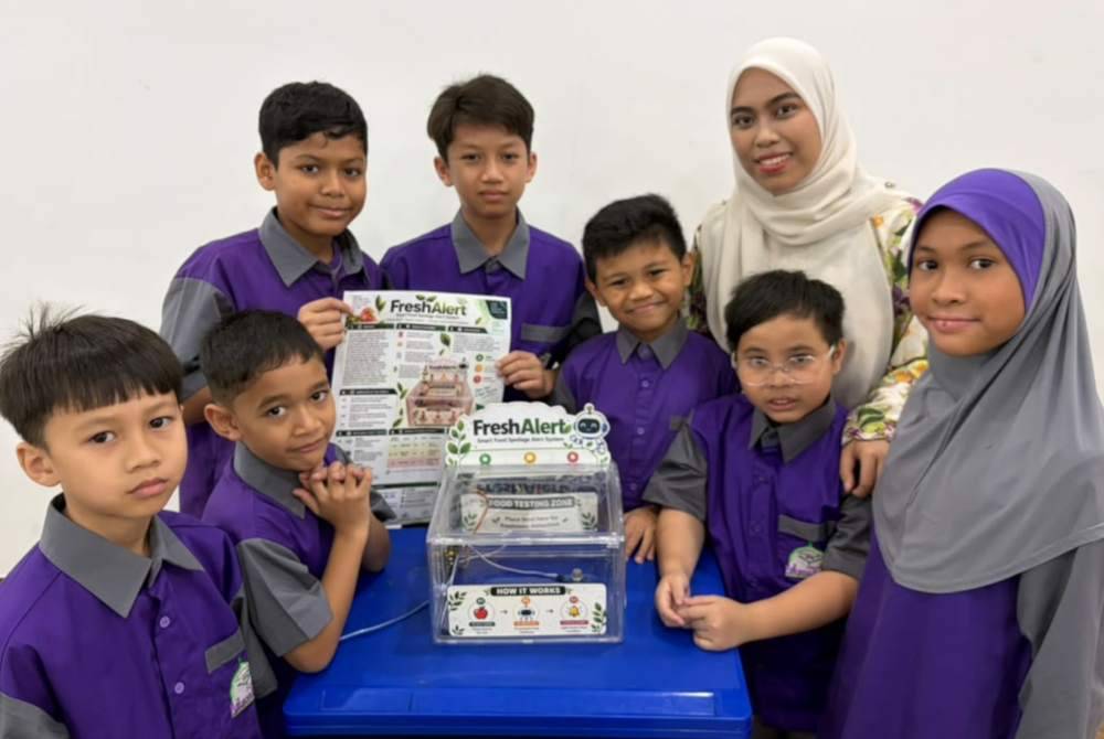 Pencipta muda Al-Amin Darul Musthofa bersama guru pembimbing menunjukkan inovasi Freshalert yang meraih pingat emas di X-CIPTA 2026.
