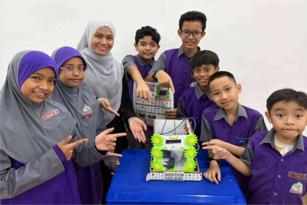 Pencipta muda Al-Amin Darul Musthofa bersama guru pembimbing menunjukkan inovasi Growvision yang meraih pingat emas di X-CIPTA 2026.