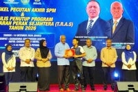 Khairudin (empat dari kiri) menyampaikan sijil kepada wakil pelajar sempena Bengkel Pecutan Akhir SPM dan Majlis Penutupan Program TRAS Tahun 2026. 