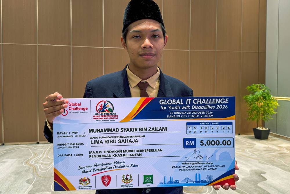 Muhammad Syakir menerima sumbangan wang tunai berjumlah RM5,000 dalam Majlis Pemberian Bantuan sebagai tanda sokongan dan penghargaan terhadap pencapaiannya. FOTO: BERNAMA