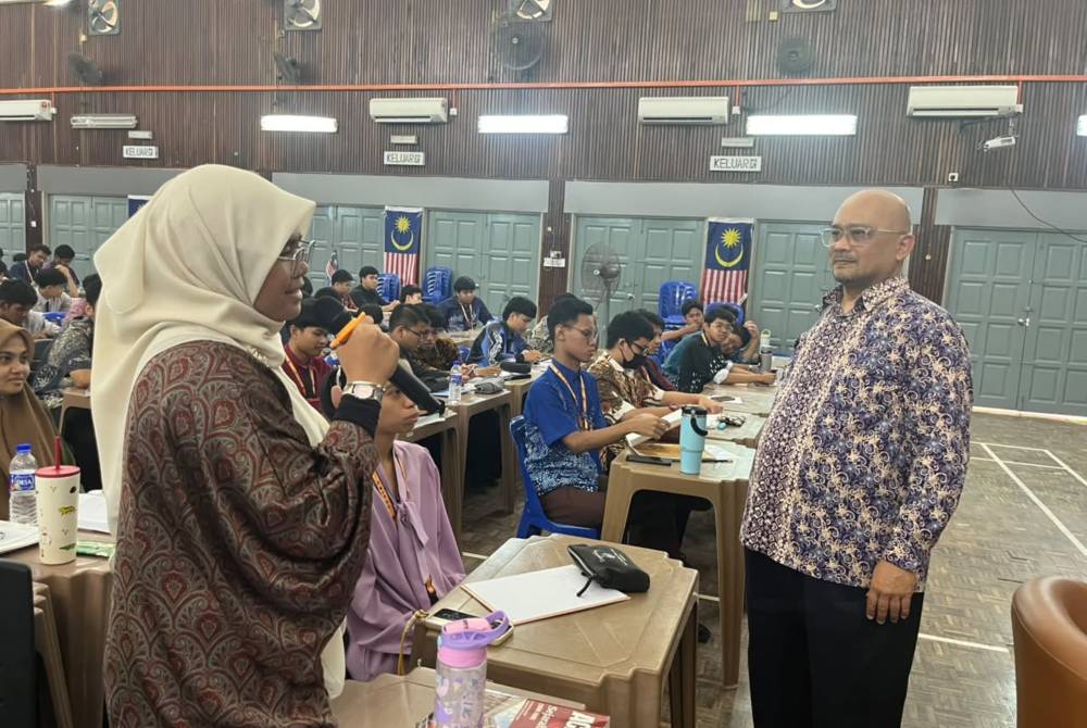 Kapten (B) Abdul Rahmat (kanan) berinteraksi dengan pelajar dalam sesi soal jawab.