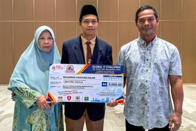 Muhammad Syakir (tengah) bersama ibu, Habsah Ismail, 62, (kiri) dan bapa Zailani Zakaria, 63, (kanan) dalam Majlis Pemberian Bantuan kepadanya pada Khamis. FOTO: BERNAMA 