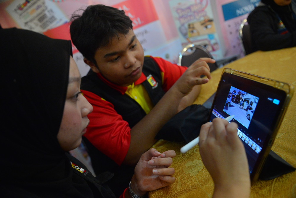 Peserta bekerjasama untuk menyiapkan suntingan video yang direkod bersama.
