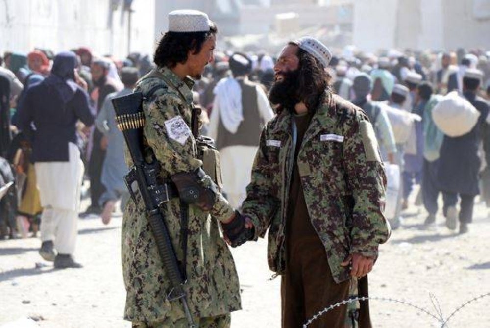 Taliban stand guard as people move forward to cross into Pakistan at Pakistan-Afghanistan border in Spin Boldak, Afghanistan, Nov 3, 2021. Photo from EPA