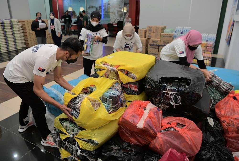 Volunteers from the Southern Volunteers group organising various types of contributions from 20 local companies worth RM400,000 for flood victims at the Sukma Secretariat Office in East Ledang. (Source: Bernama)