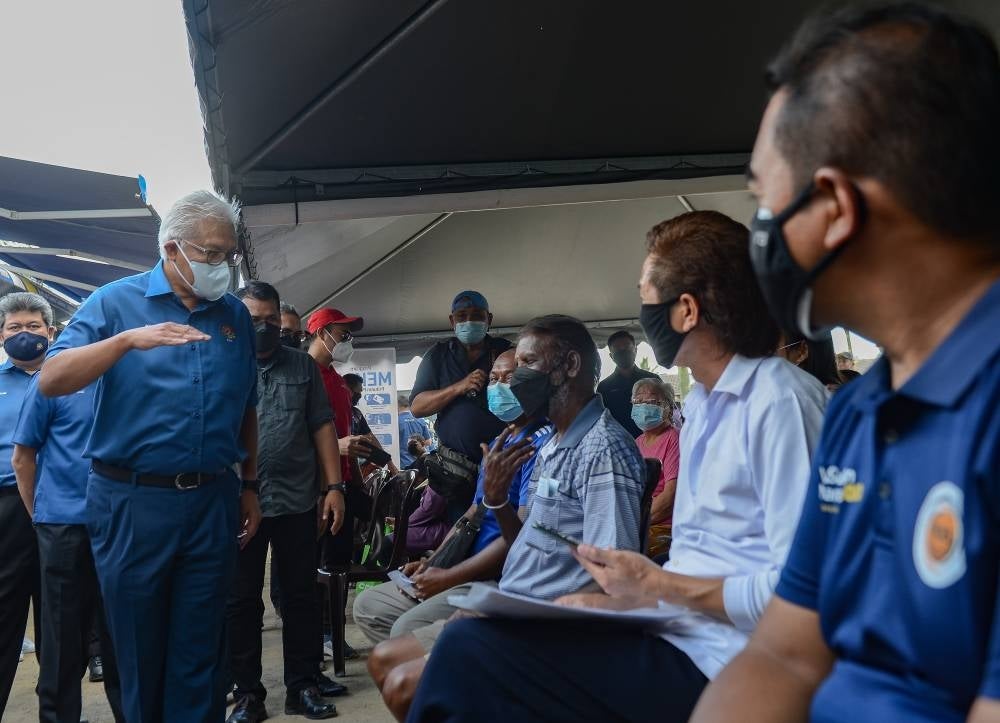 Hamzah greetings residents, who have been displaced due to floods, at Taman Sri Nanding Community Hall on Dec 7. (Source: Bernama)