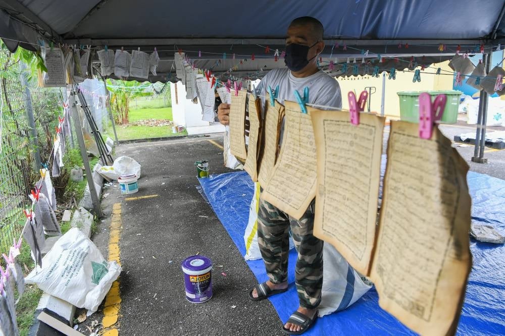 A Wilayah Persekutuan Religious Department (JAWI) volunteer, Muhd Rosdan Abd Samad، 50، hanging pieces of pages from the Quran before they are respectfully disposed off at the Darul Kalam Quran disposal centre. -- Bernama Photo.