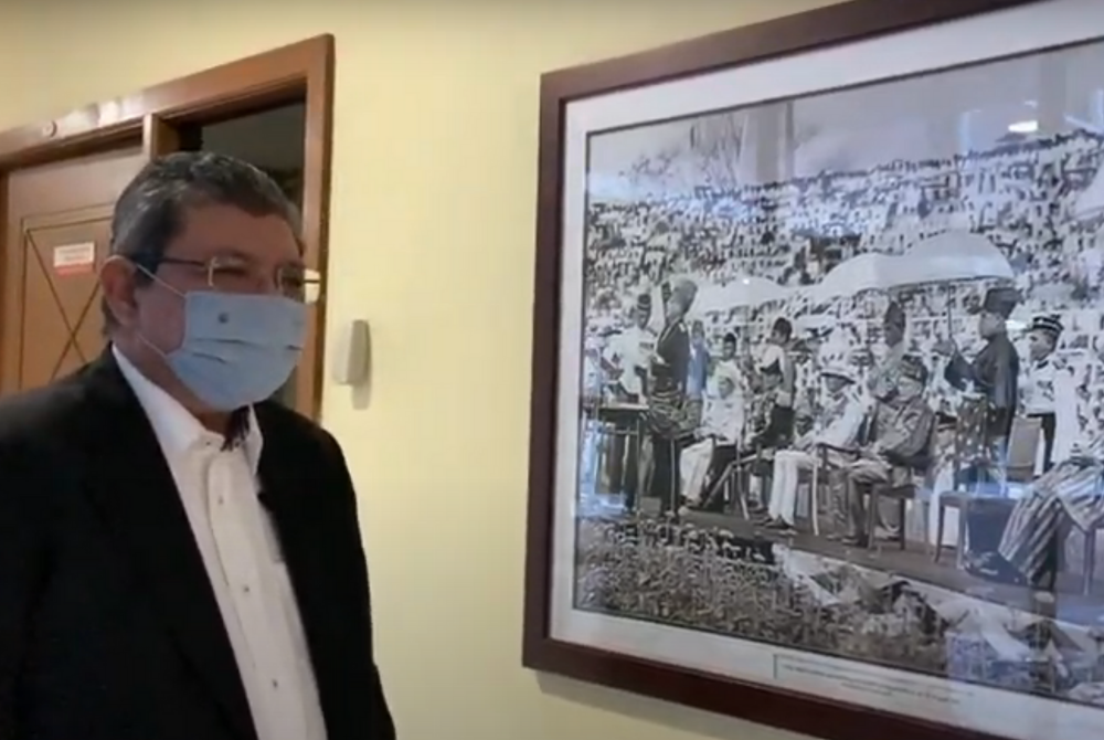 A screengrab of Saifuddin on Politically Frank admiring a framed photo of first Prime Minister Tunku Abcul Rahman at Stadium Merdeka.