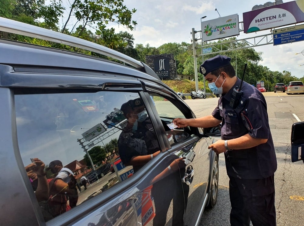 The police inspecting motorists for traffic violations during Ops Selamat 17 in conjunction with the Chinese New Year holiday season, at Ayer Keroh toll, Melaka on Wednesday (Feb 2)