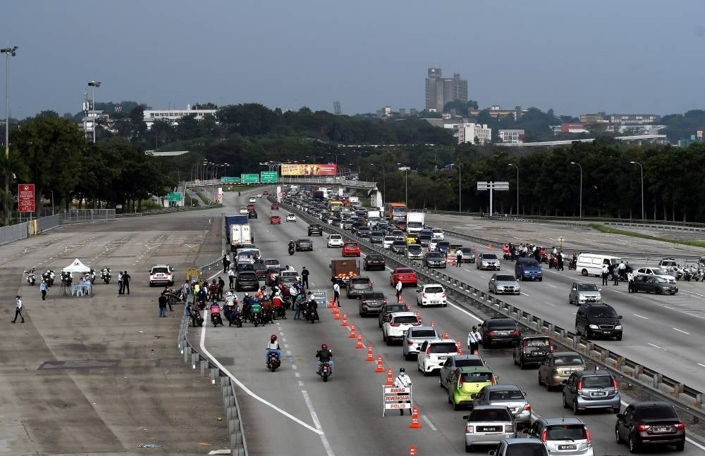Traffic policemen conducting checks on road users during Op Selamat 17 held in conjunction with Chinese New Year at the Federal Highway on Jan 31, 2022. - BERNAMA