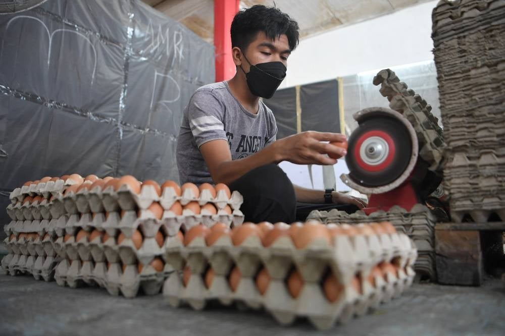 An egg seller washing the eggs before selling them in Kampung Batu, Kuala Nerus on Feb 6, 2022. - BERNAMA
