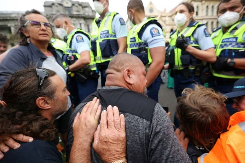 Protesters resist police before they moved in to evict mandate protesters in parliament grounds in Wellington on Thursday. - AFP