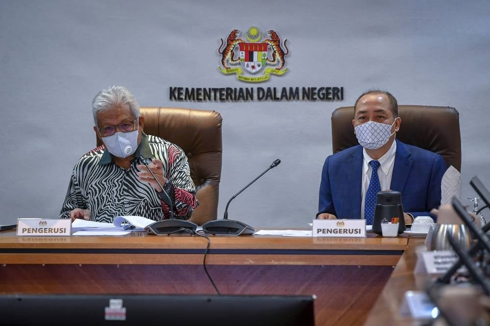 Home Minister Hamzah Zainuddin (left) and Sabah Chief Minister Datuk Seri Hajiji Noor (right) deliberating suggestions during the Committee on the Management of Foreign Nationals in Sabah (JKPWAS) meeting earlier today. - Bernama Photo. 