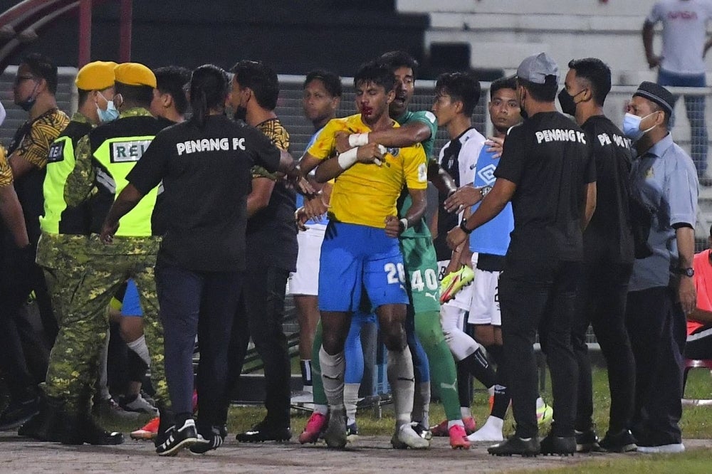 Adib Raop who was injured held by Penang FC goalkeeper Shafiq Afifi Suhaimi, during the Terengganu Menteri Besar Cup final in Kuala Terengganu on Feb 9, 2022. - BERNAMA