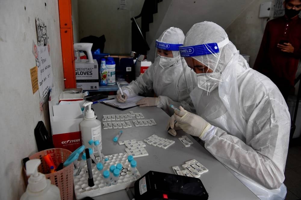 Healthcare workers examining the result of the Covid-19 RTK-Antigen test, at a private clinic. - BERNAMA