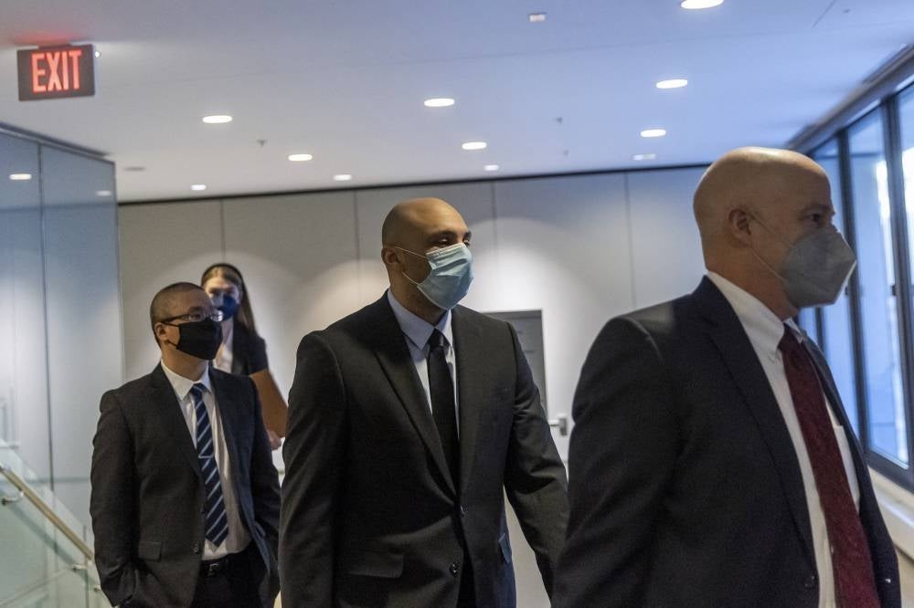 Former Minneapolis police officers Tou Thao (L) and Alexander Kueng (C), along with his attorney Thomas Plunkett (R), with one other former Minneapolis police officer charged with federal civil rights violations in George Floyd's death. - AFP