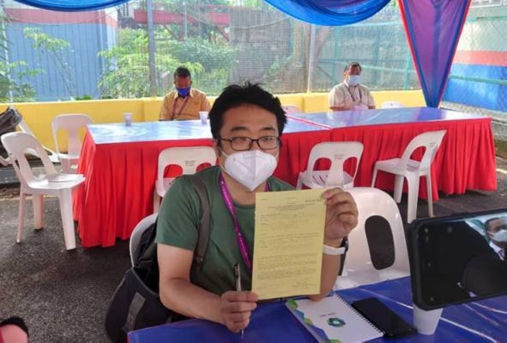 Sin Chew Daily journalist, Weng Kian Yong with the RM1,000 compound issued for allegedly breaking Covid-19 SOPs. Pic from Astro Awani