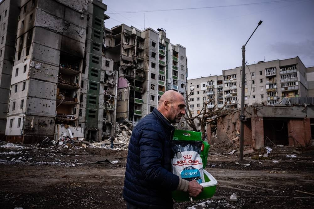 A man walks in front of a residential building damaged in a shelling in the city of Chernihiv on March 4, 2022. - AFP