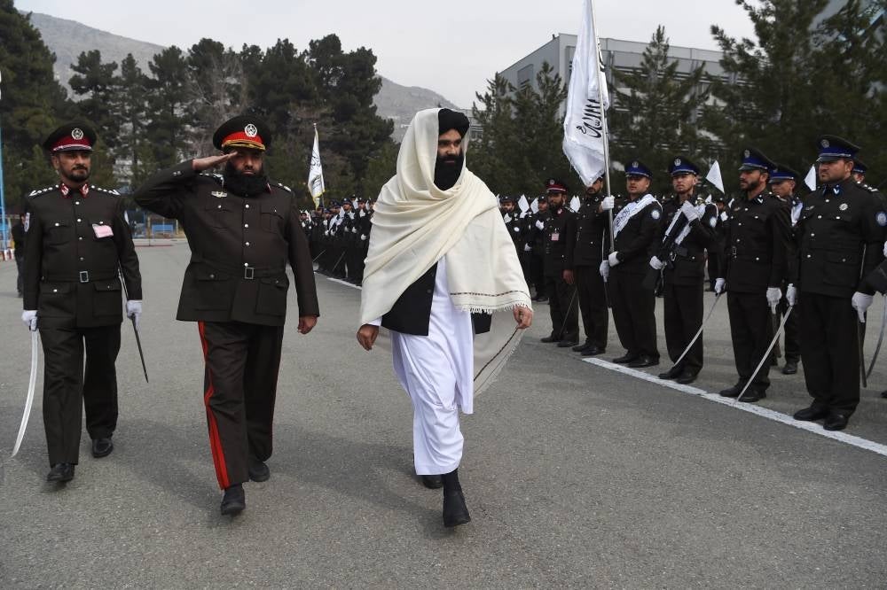 Taliban Interior Minister Sirajuddin Haqqani reviews new Afghan police recruits standing in formation during a graduation ceremony at the police academy in Kabul on March 5, 2022. - AFP