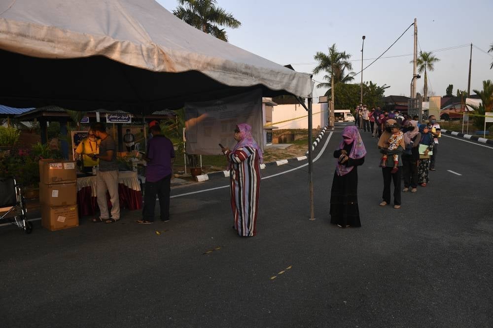 Voters lining up as early as 7.30am at Sekolah Agama Taman Sri Lambak to vote in the Johor state election, today. - BERNAMA