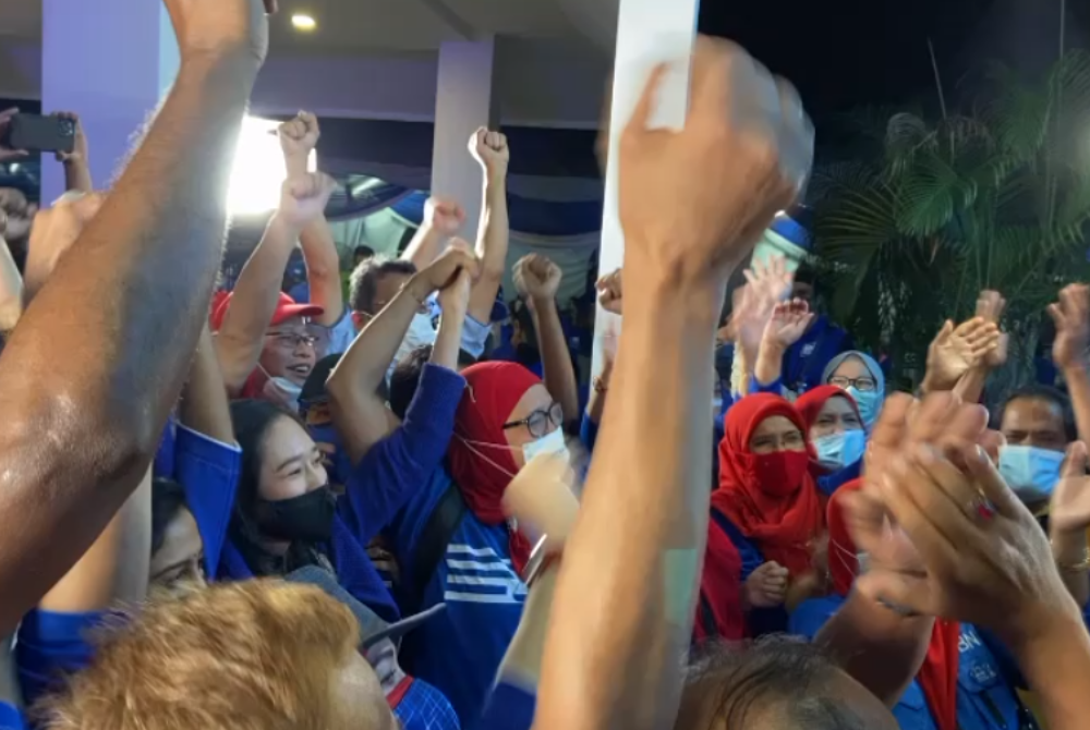 Clad in blue, BN supporters celebrate an early victory following unofficial but favourable results for the party.
