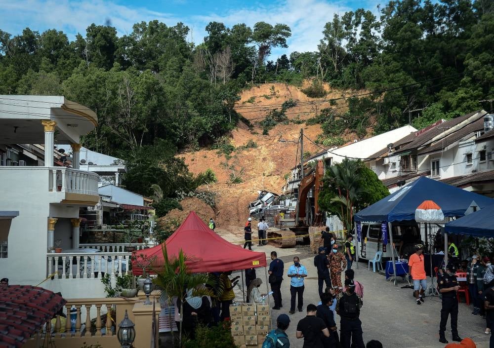 Uniformed officers from various agencies assessing at the damage done by the landslide in Taman Bukit Permai 2, Ampang. - Bernama Photo
